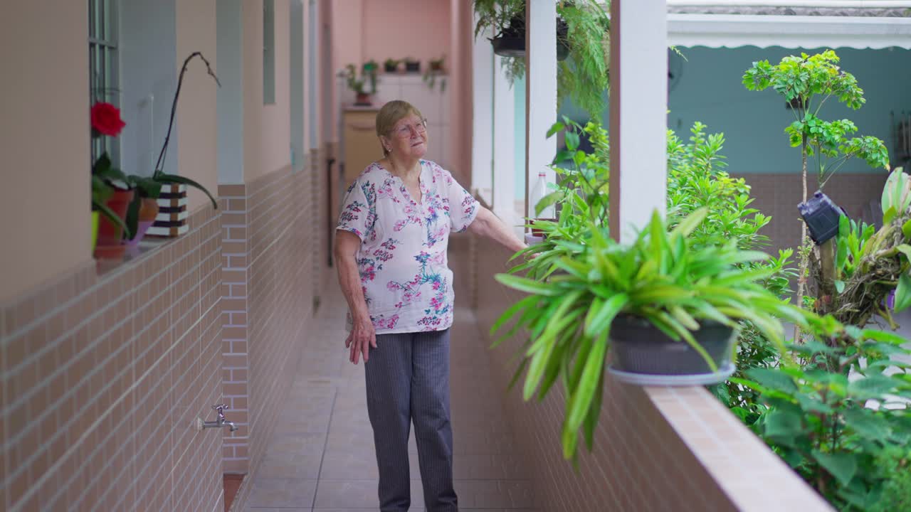 沉思的成熟女人站在家里的走廊外靠思考生活。内省的80年代老人反思过去的想法视频素材