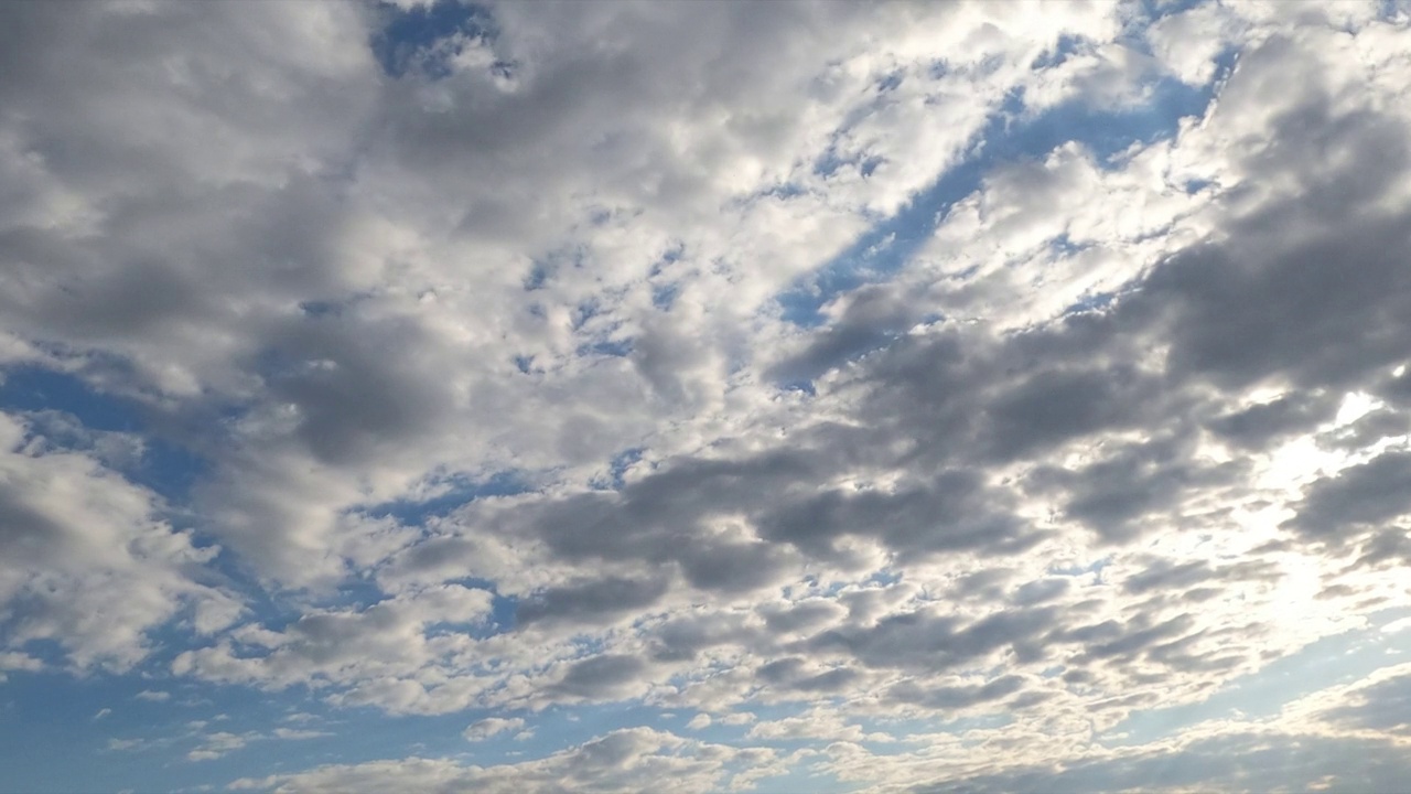 灰色的云缓缓地在天空中飘过。阴雨的云景在大气中形成，但随后蓝天出现。间隔拍摄。视频素材