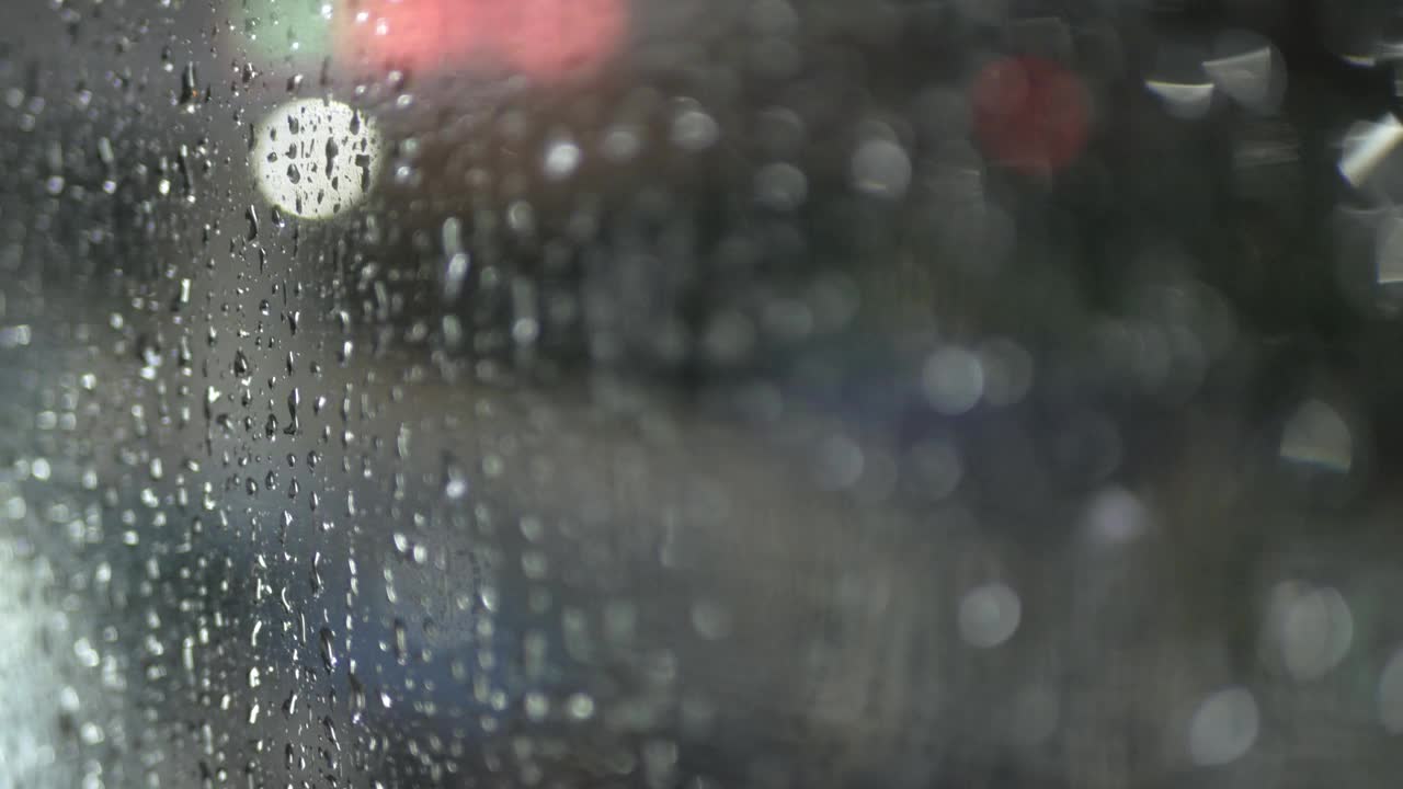 被困在城市道路上的公交车上，雨水滴在透明的玻璃窗上，4K的散景效果很好视频素材