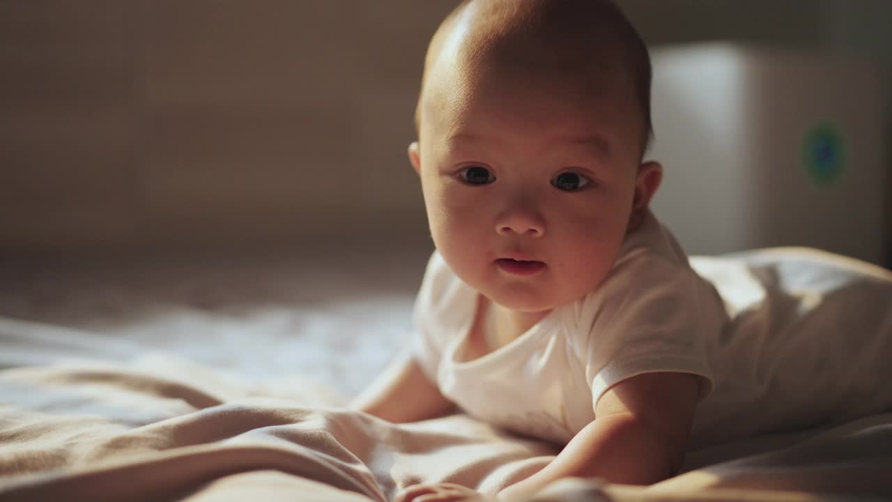 快乐的小男孩早上在卧室的婴儿床上微笑和快乐视频素材