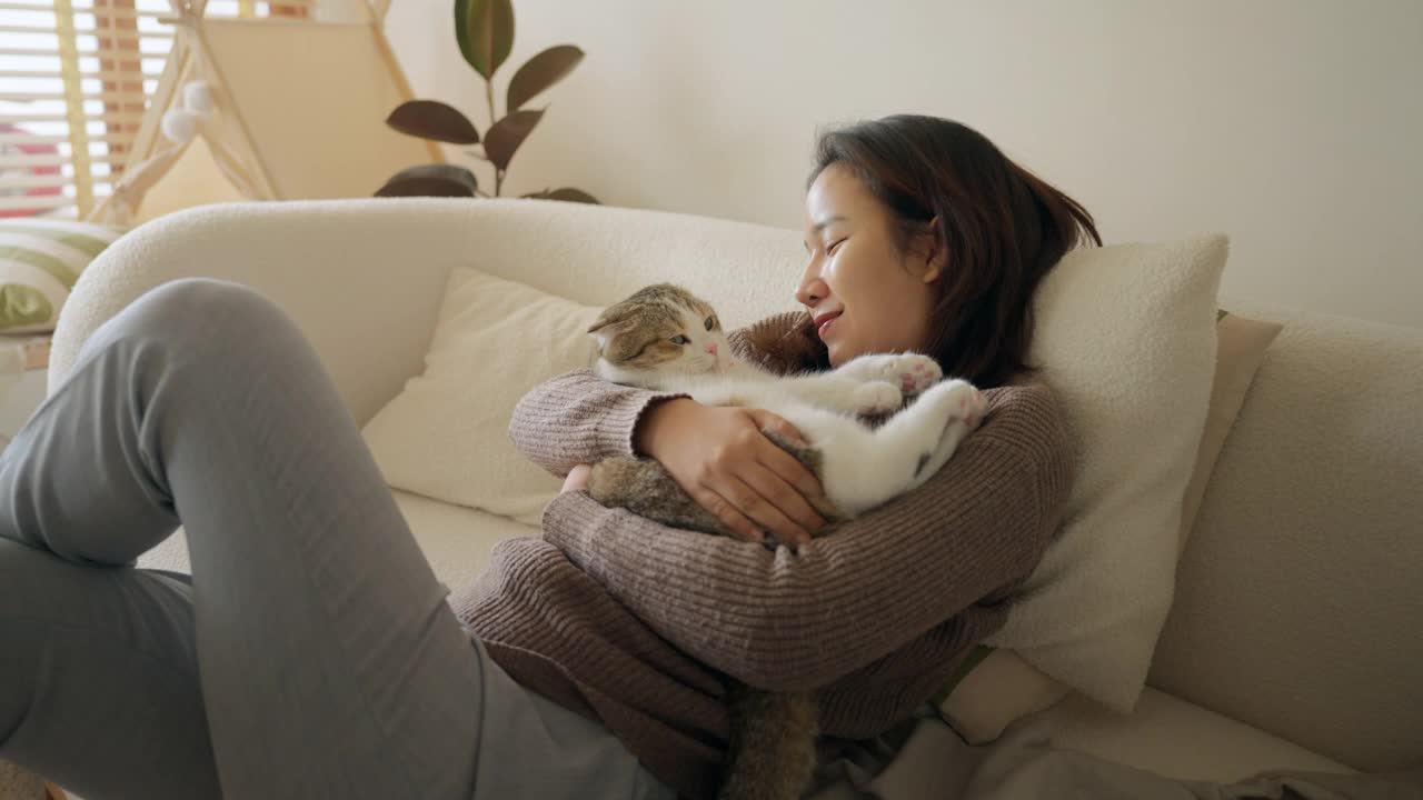 开朗的年轻女子，家里有只可爱的猫视频素材