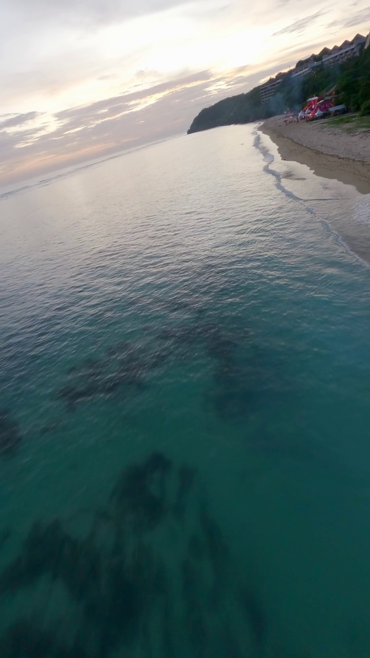 垂直视频。低海景海洋大海泡沫海浪水日落海滩山4k视频素材