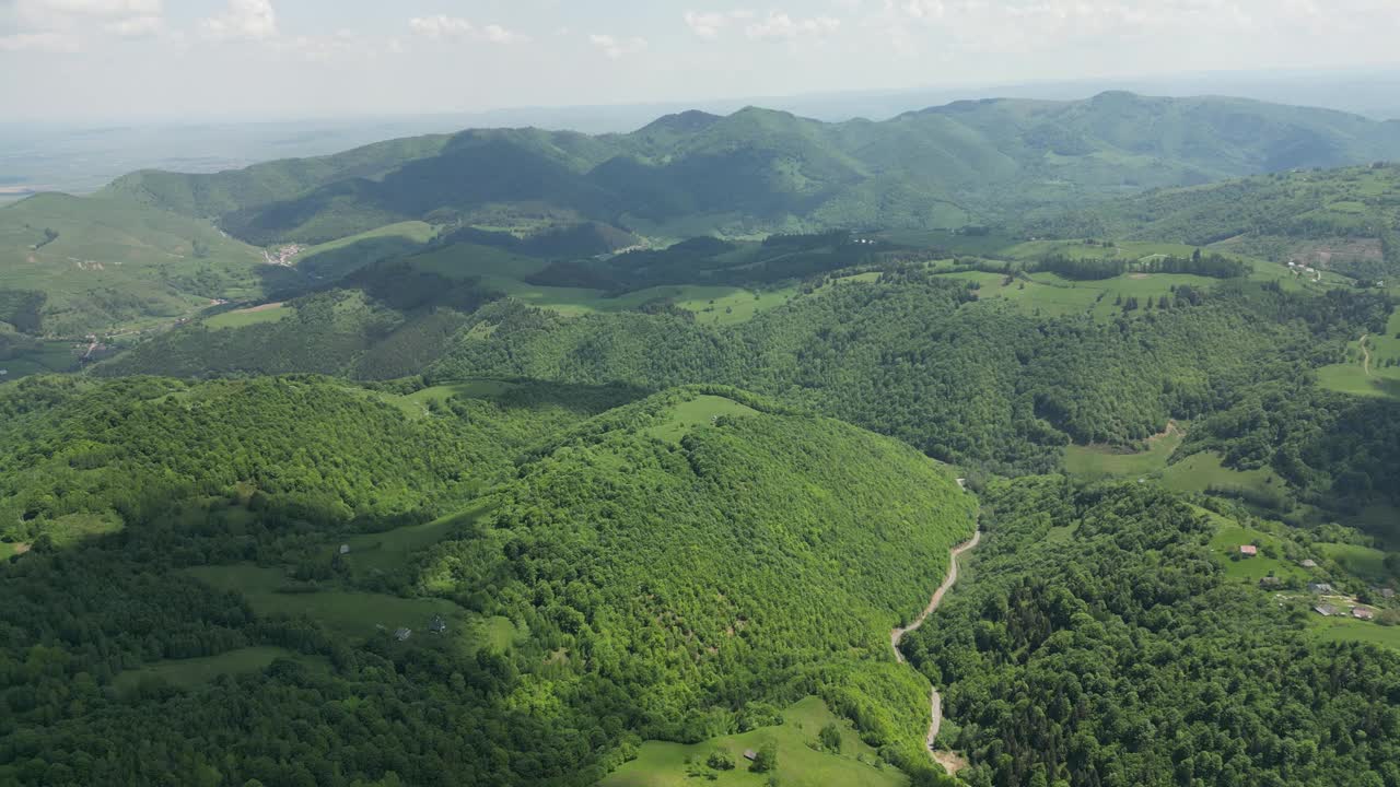 航拍到的青山上覆盖着建筑和道路视频素材