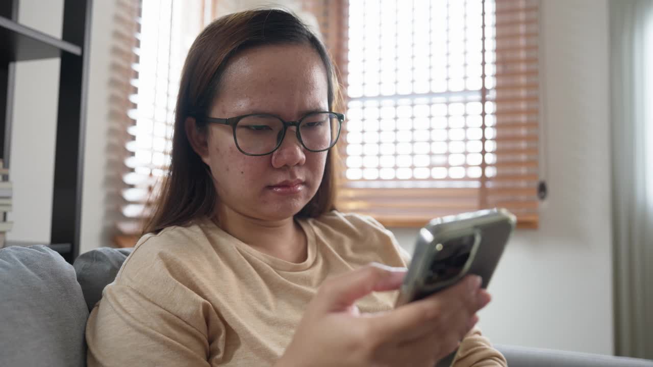 忧郁的年轻亚洲女人在用手机。不高兴听到床上消息视频素材