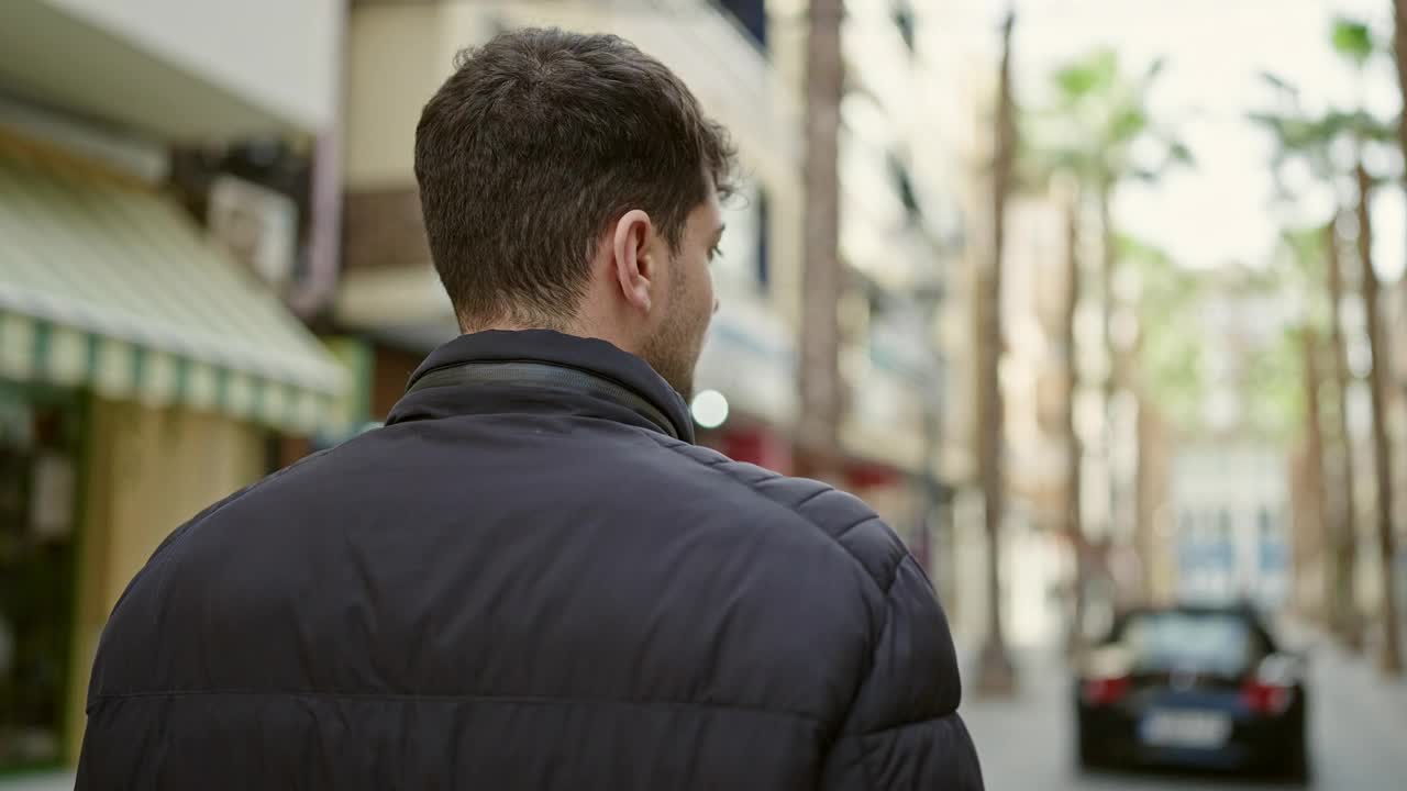 年轻的西班牙裔男子向后站在街上视频素材