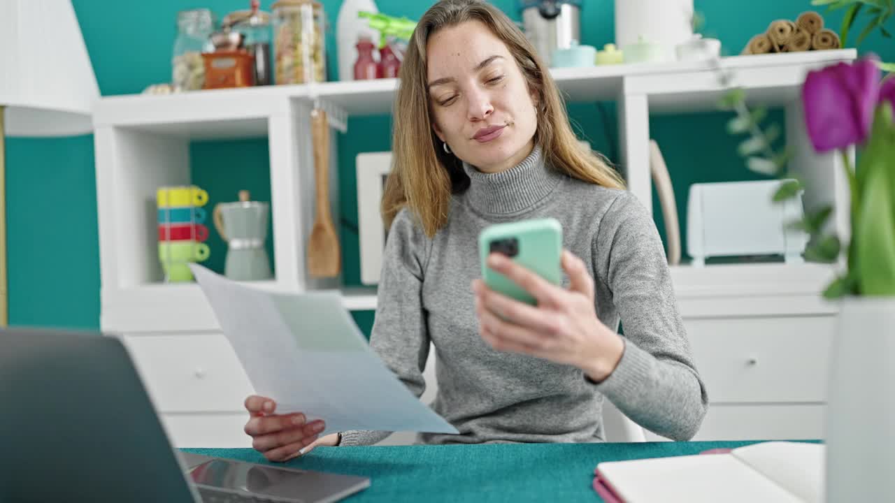 年轻的白人女性在餐厅用智能手机阅读文件视频素材