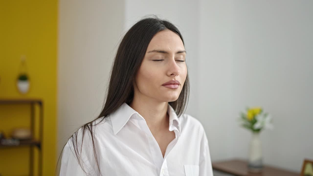 年轻美丽的西班牙女人闭着眼睛在家里呼吸视频素材