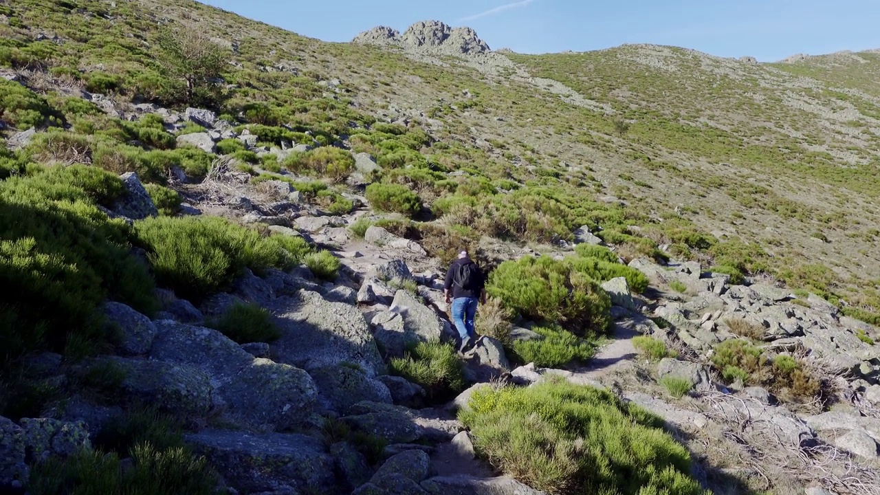 一名男子在西班牙中部瓜达拉马山脉的斜坡上徒步旅行。视频素材