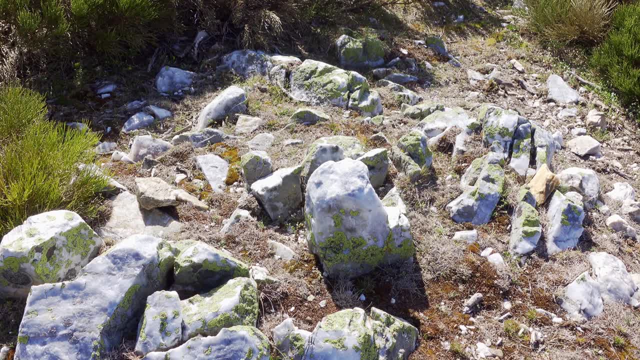 一名男子正在打一块漂亮的白色石头，它位于瓜达拉马马德里的山顶。视频素材