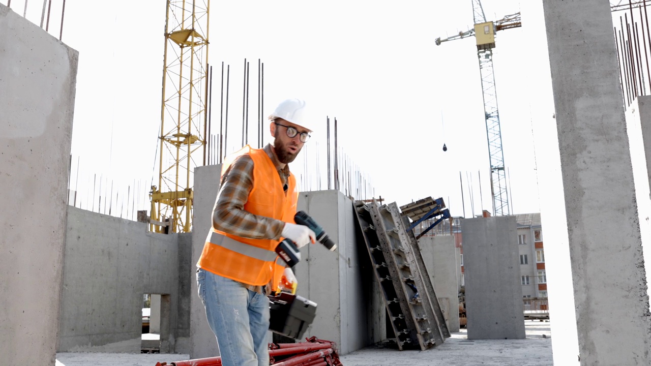 滑稽的建筑工人跳舞。戴着头盔的建筑工人的积极舞蹈。穿着建筑工人制服的建筑工程师在他的工作场所跳舞视频素材