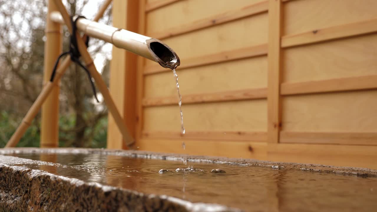 日本传统迷你花园中从竹管水龙头流出的水。视频素材