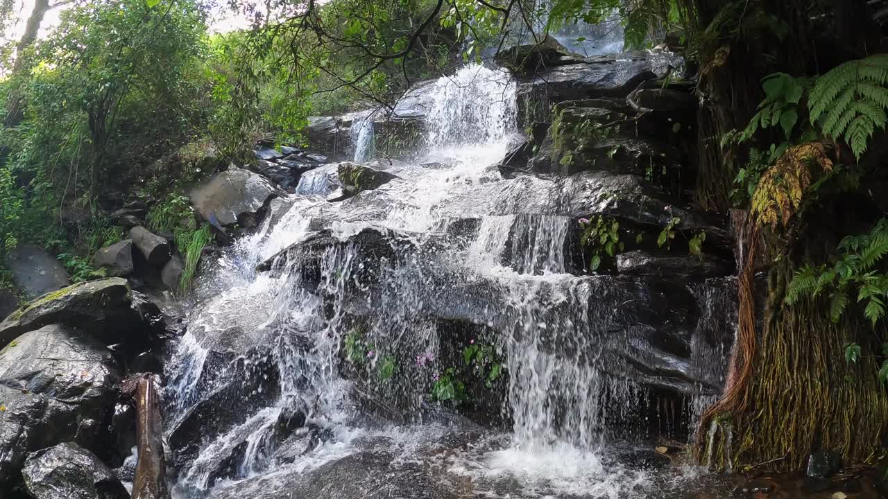 一种小瀑布，水流平滑地从岩石和石头上倾泻而下视频素材