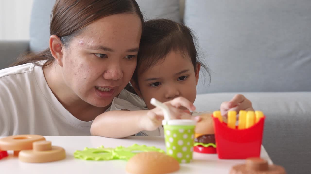 童年的快乐，妈妈和小女孩一起玩塑料儿童玩具视频素材