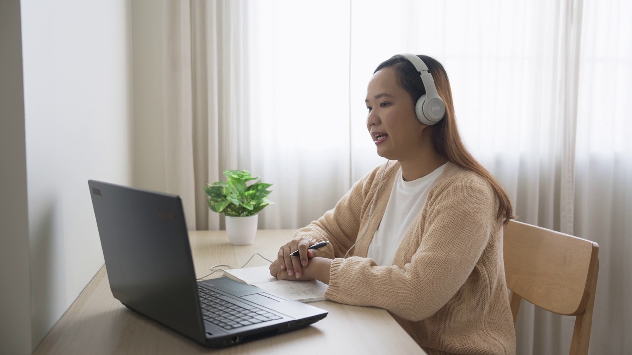 戴着耳机的女商人在家里通过视频会议开会视频素材