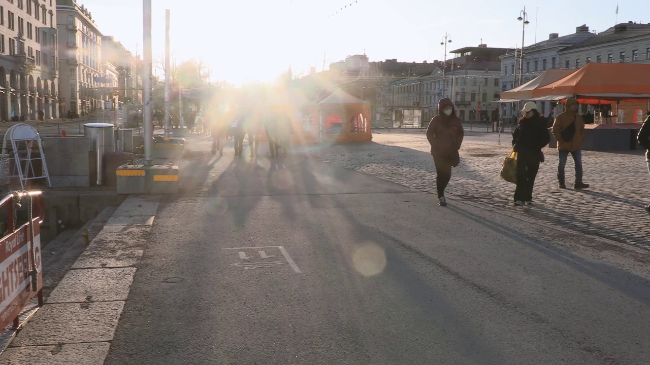 人们在夕阳的照耀下走在城市街道上视频下载