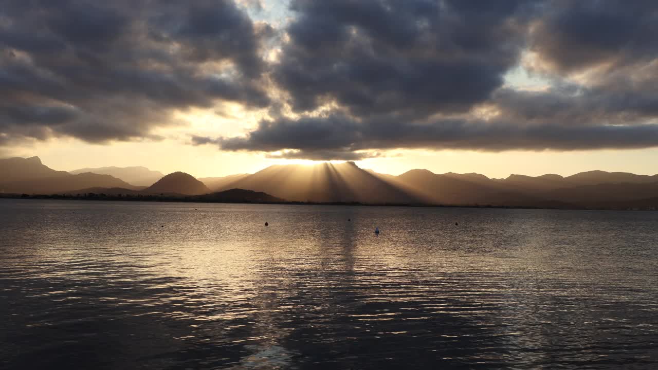 在马略卡岛的波伦卡湾，日落与壮观的天空和阳光在山脉和海洋上的时间流逝视频素材