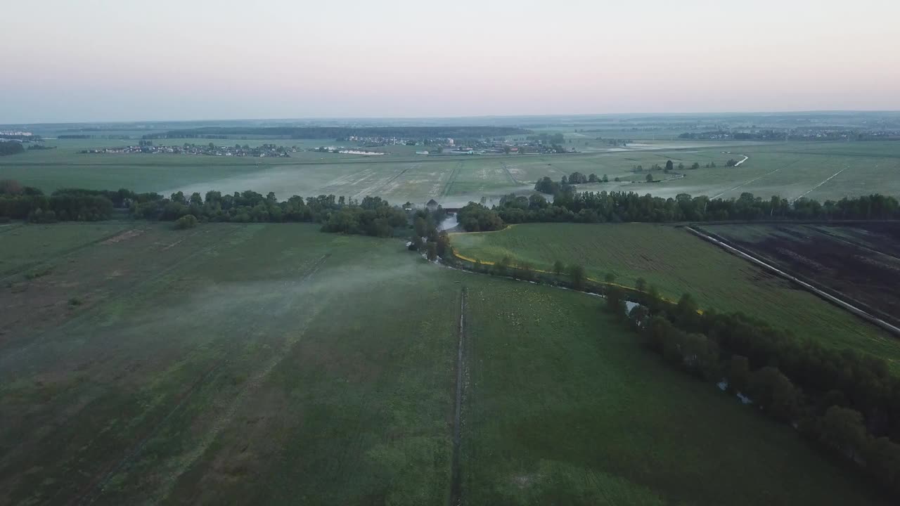 春天早晨的风景。铁路桥横跨在盛开的草地上平静的河流。视频素材