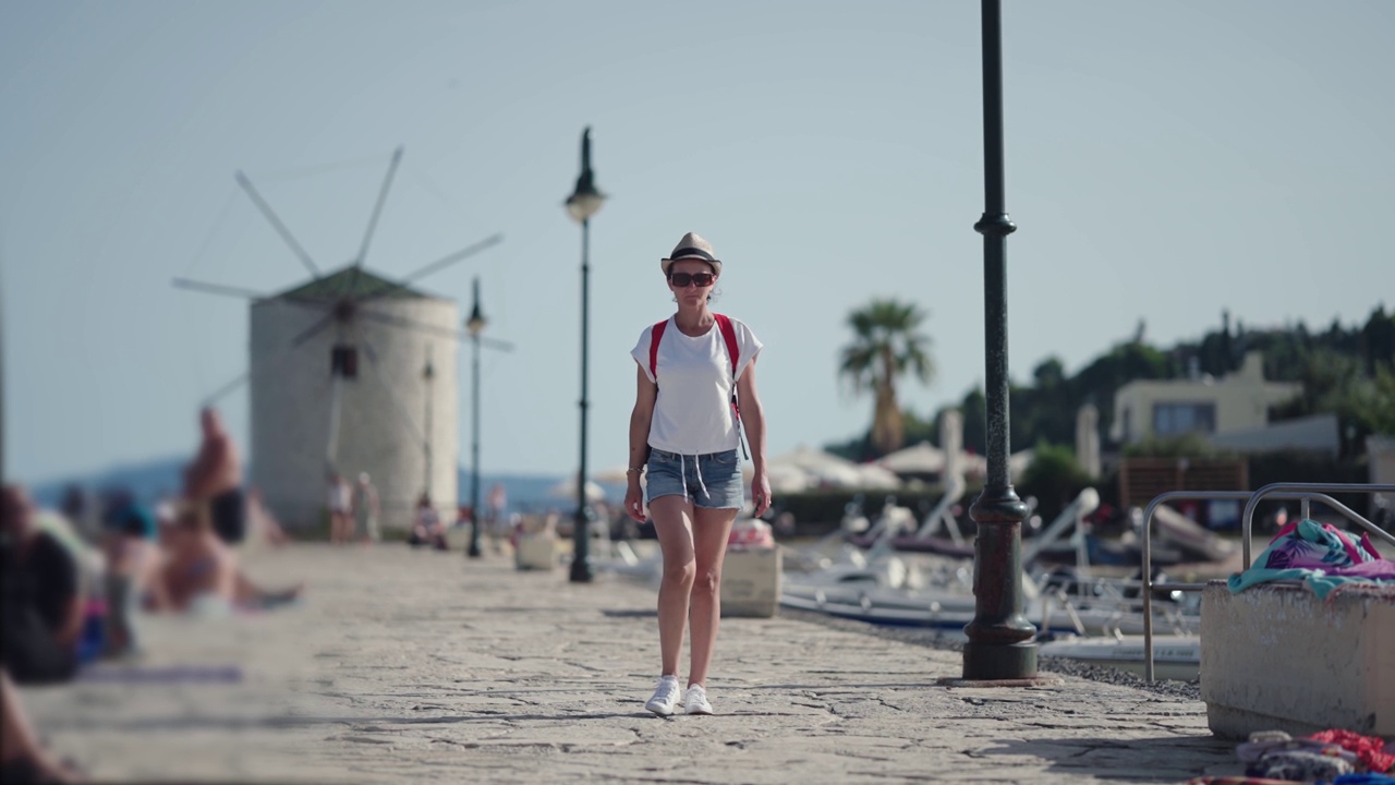 希腊科孚岛的女游客。快乐优雅的时尚模特在希腊克罗弗岛的老城区享受假期，慢镜头视频素材