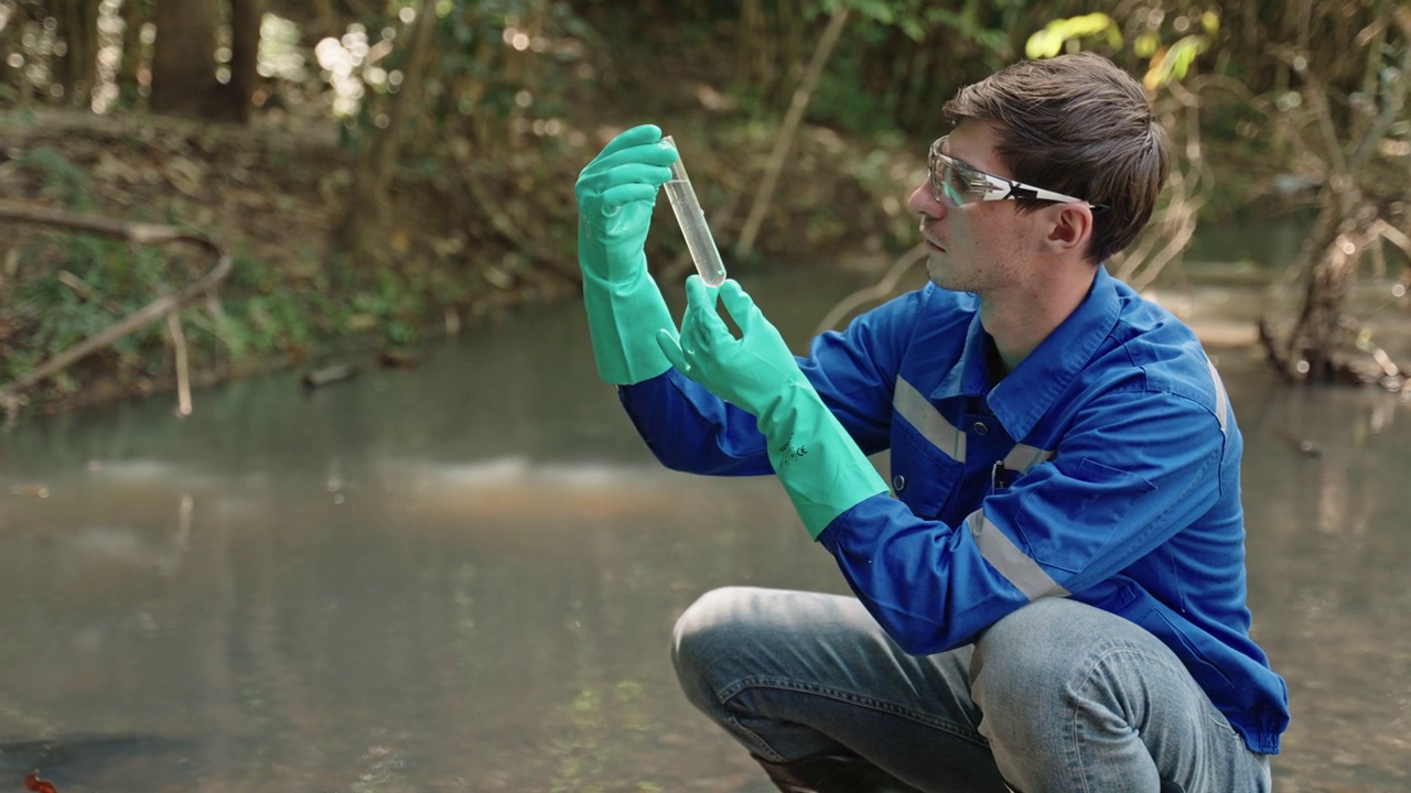 两名男性生物学家在当地的一条河里测试水。生态学家们穿着休闲服，在湖上探险，取水样。视频素材