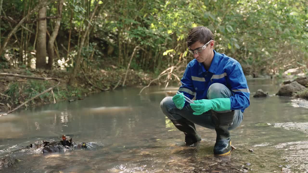 两名男性生物学家在当地的一条河里测试水。生态学家们穿着休闲服，在湖上探险，取水样。视频下载