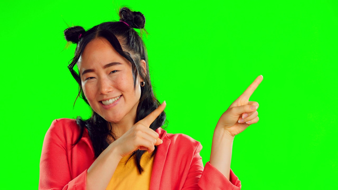 Happy asian woman, pointing and green screen for product placement, marketing or advertising against a studio background. Portrait of female smile showing point of advertisement, news or notification视频素材