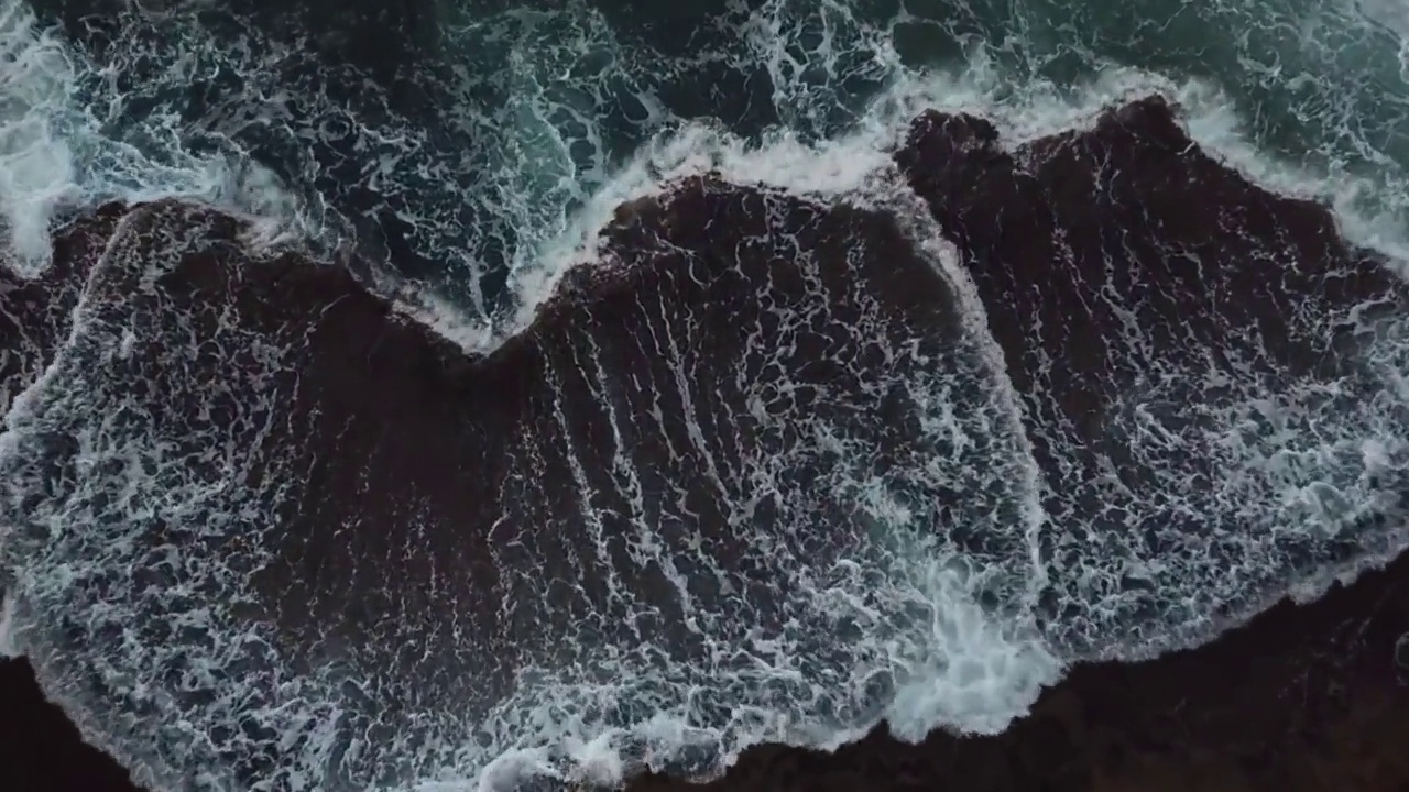 海浪拍打着海岸，拍打着沙滩，撞击着岩石视频素材