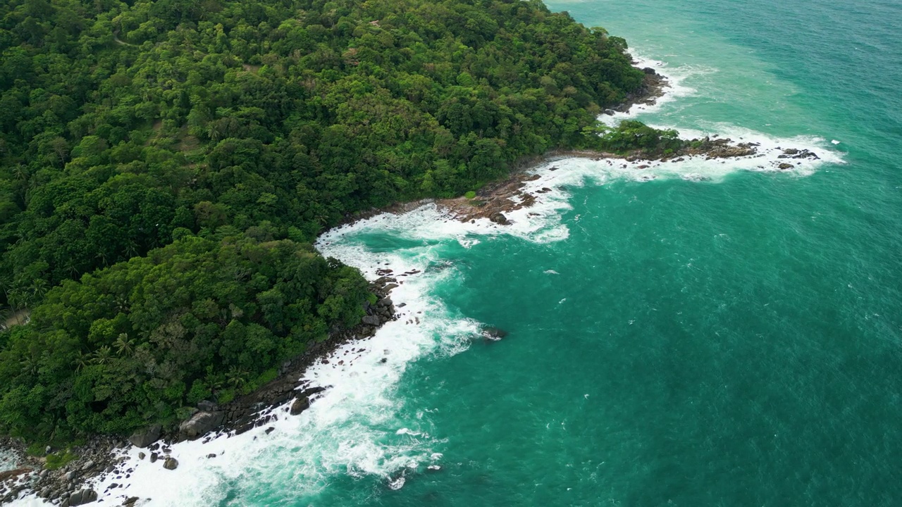 海滩鸟瞰图椰子树和巨大的海浪造成的强风造成的巨浪冲刷在泰国普吉岛海岸线上的山丘。视频素材