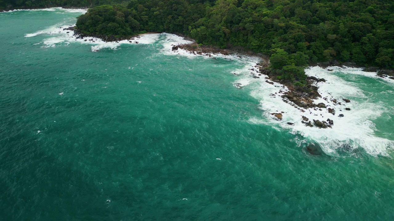 海滩鸟瞰图椰子树和巨大的海浪造成的强风造成的巨浪冲刷在泰国普吉岛海岸线上的山丘。视频素材