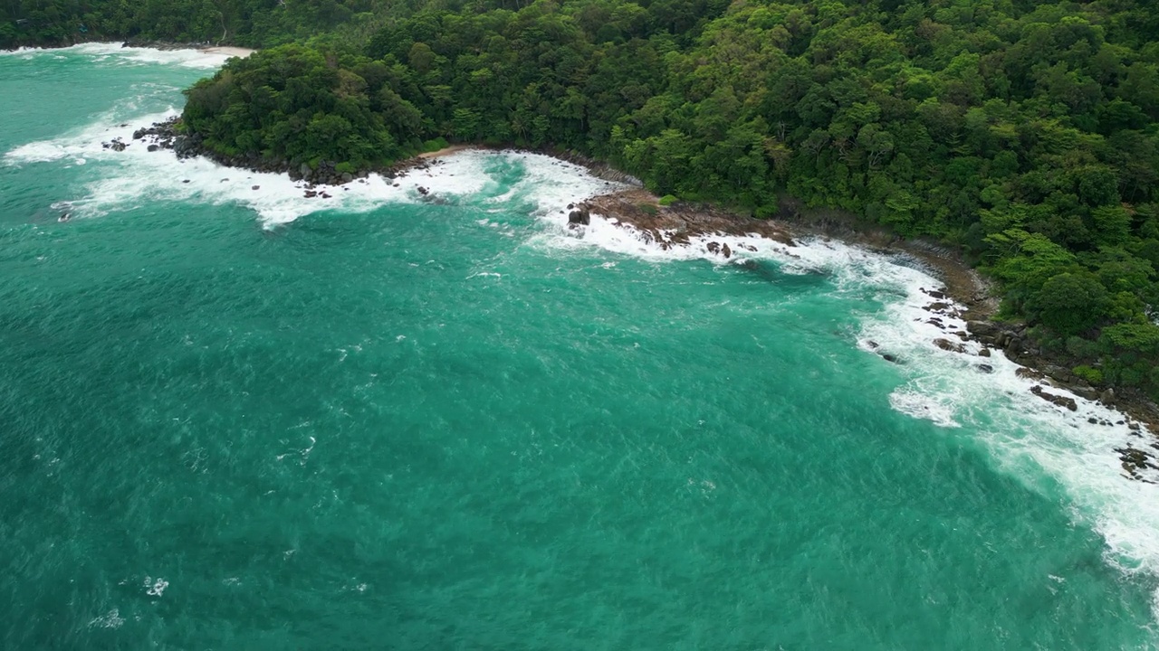 海滩鸟瞰图椰子树和巨大的海浪造成的强风造成的巨浪冲刷在泰国普吉岛海岸线上的山丘。视频素材