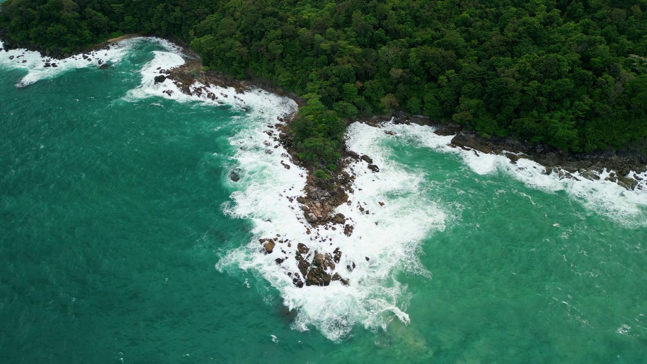 海滩鸟瞰图椰子树和巨大的海浪造成的强风造成的巨浪冲刷在泰国普吉岛海岸线上的山丘。视频素材