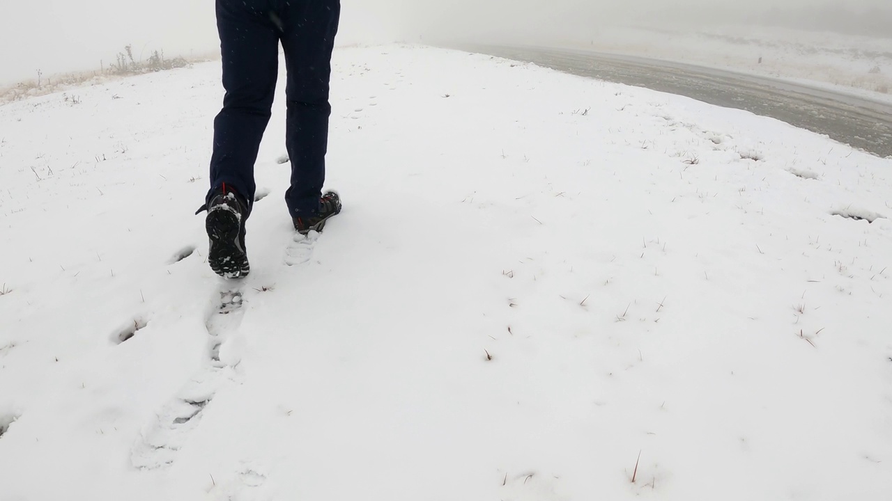 一个人走在雪地里，后视图，鞋印特写视频素材