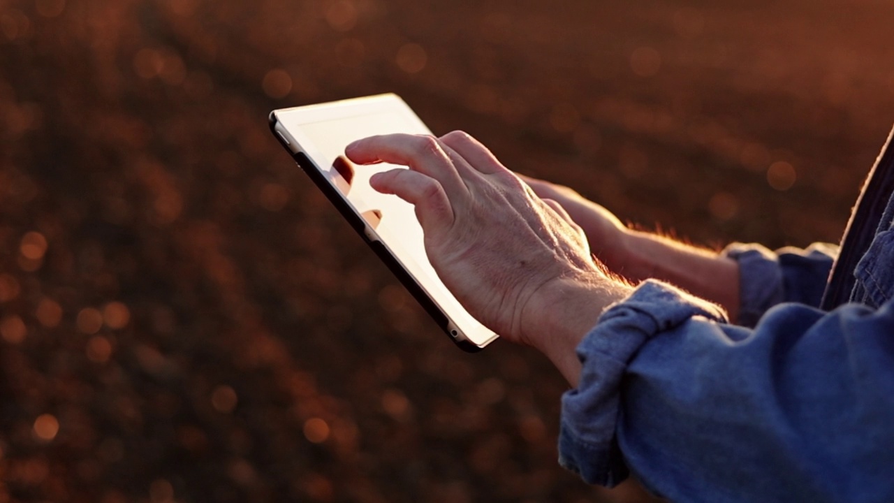男性农民的手在耕地上使用数字平板电脑，以控制土壤质量，土地准备播种作物和种植蔬菜。智能农业技术和农业。视频素材
