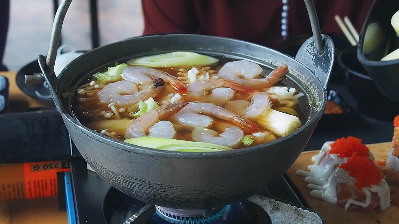 将豆腐倒入涮锅。涮锅或寿喜烧。日本的食物。在日本餐厅享受火锅涮锅和寿喜烧。日本食物是高质量的食物。视频素材