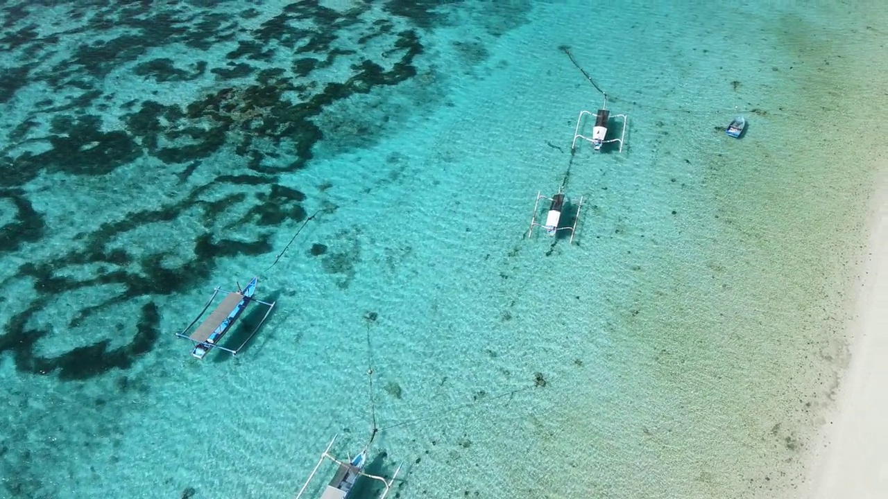 渔船在透明的海洋和热带海滩在阳光明媚的日子。鸟瞰图。视频素材