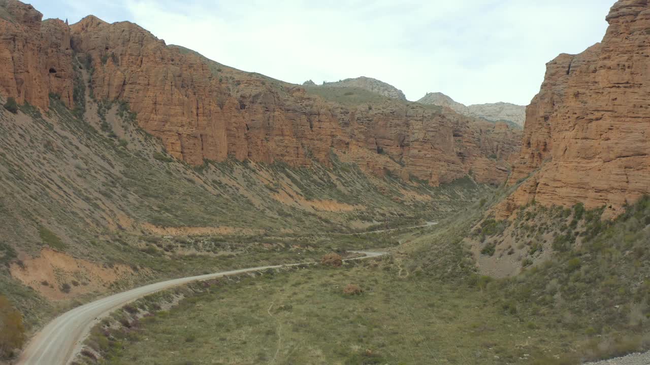 鸟瞰图红沙峡谷旁边蜿蜒的道路和树木繁茂的地区。视频素材