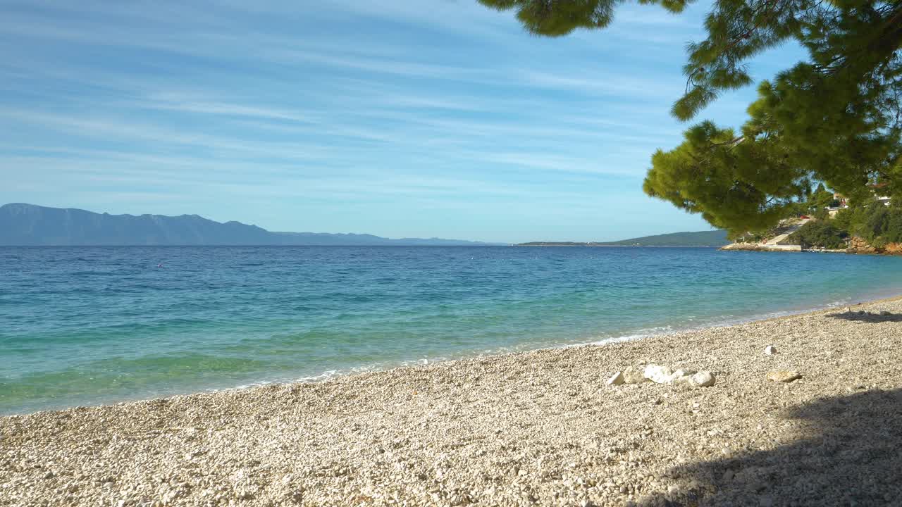 美丽而空旷的卵石海滩，在一个阳光明媚的夏日，波浪形的亚得里亚海视频素材