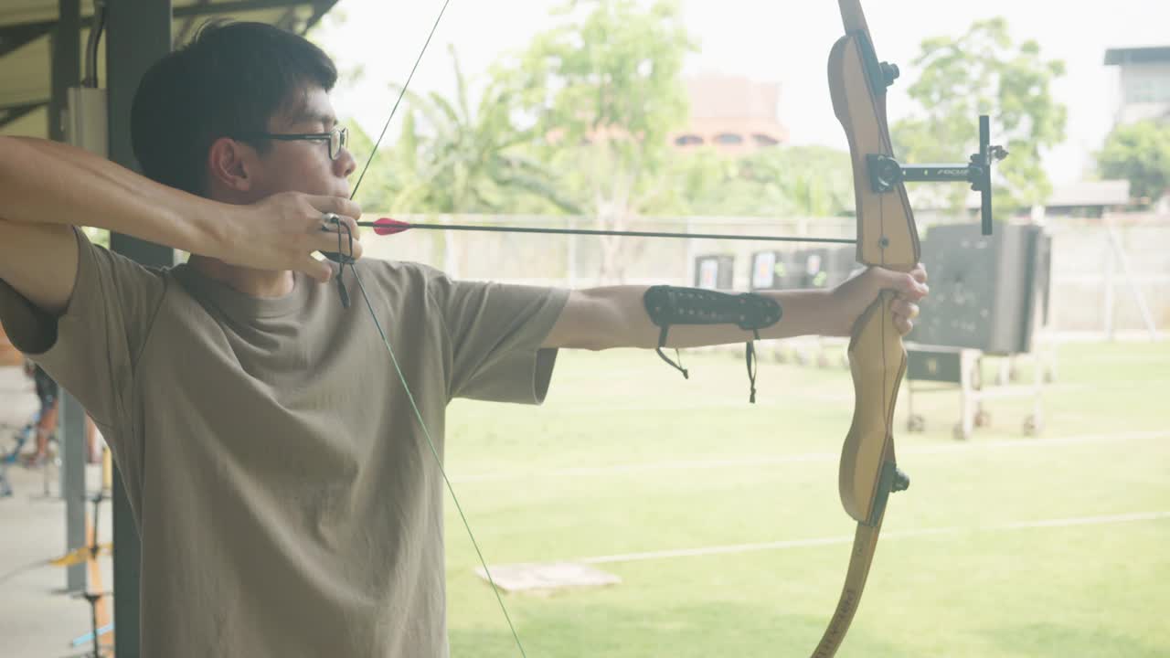 迷人的亚洲男子在靶场练习射箭。射箭。视频素材