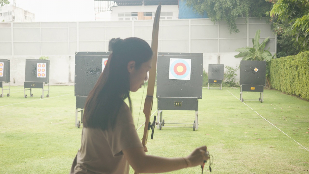 迷人的亚洲女性在靶场练习射箭。射箭。视频素材