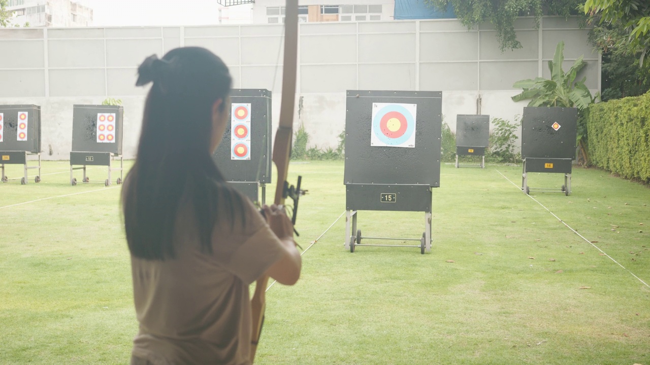 迷人的亚洲女性在靶场练习射箭。射箭。视频素材