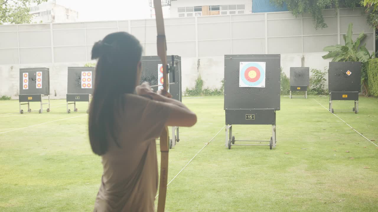 迷人的亚洲女性在靶场练习射箭。射箭。视频素材