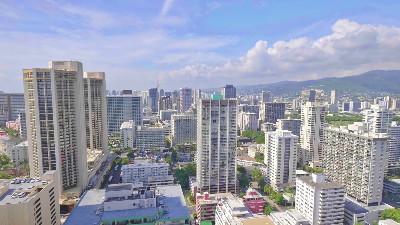 一名女子走到阳台上，欣赏着夏威夷檀香山市的美丽景色，画面为4k慢动作，每秒60帧视频素材