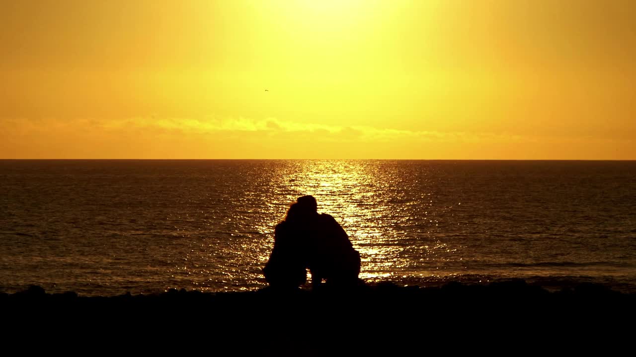 浪漫时刻在日落的海洋-一对夫妇的迷人的海边体验在4k慢动作60fps视频素材