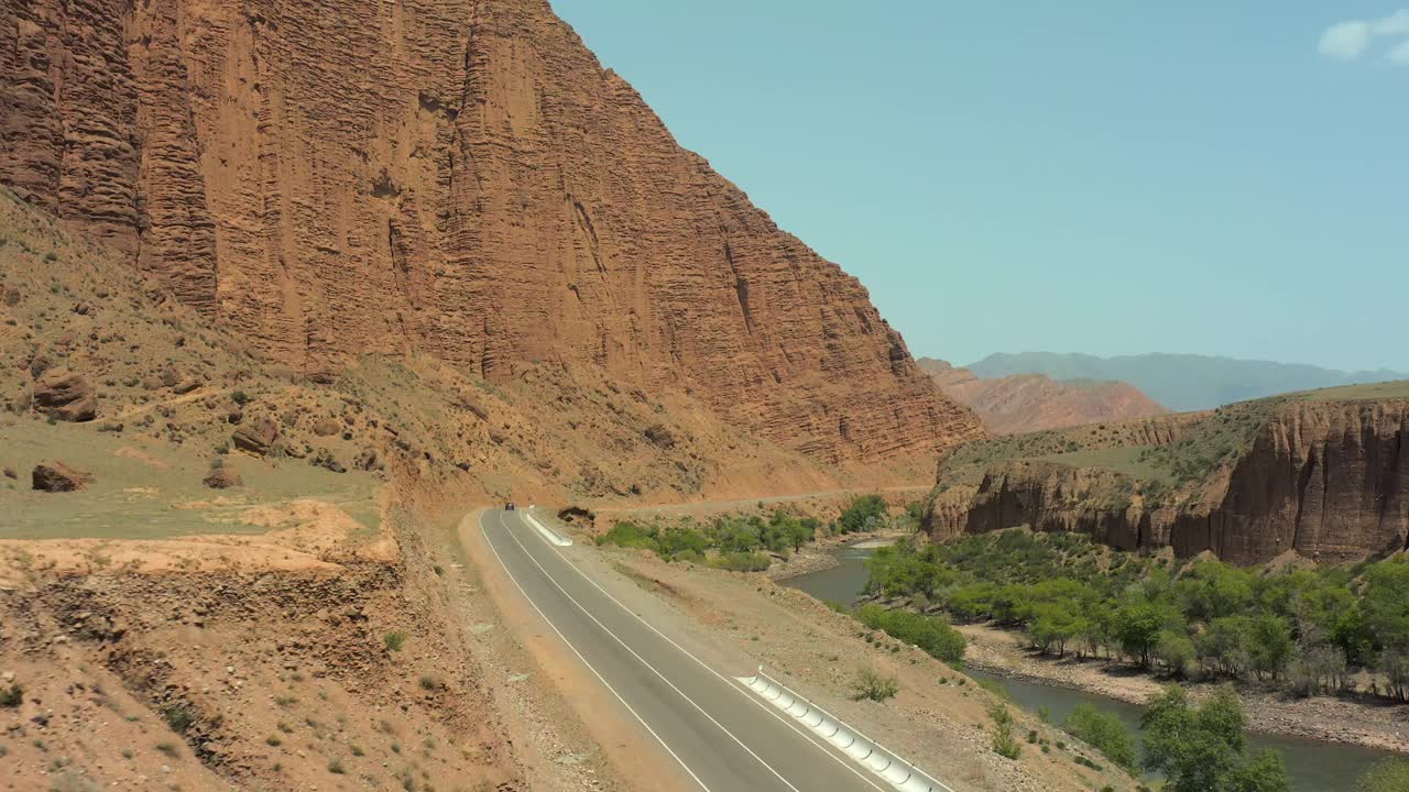 从沿着峡谷和河流的道路上飞行的无人机上看风景如画。视频素材