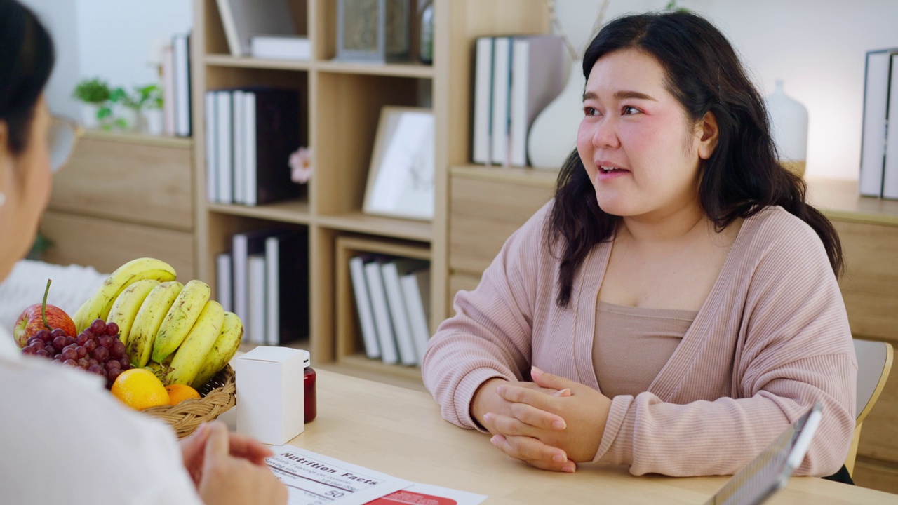 一位营养学家正在进行一项问卷调查，并为肥胖的年轻女性提供减肥饮食方面的咨询。视频素材