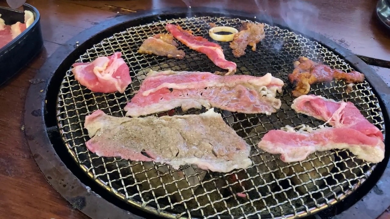 各式各样的生肉在炉子上烤成韩式烤肉视频下载