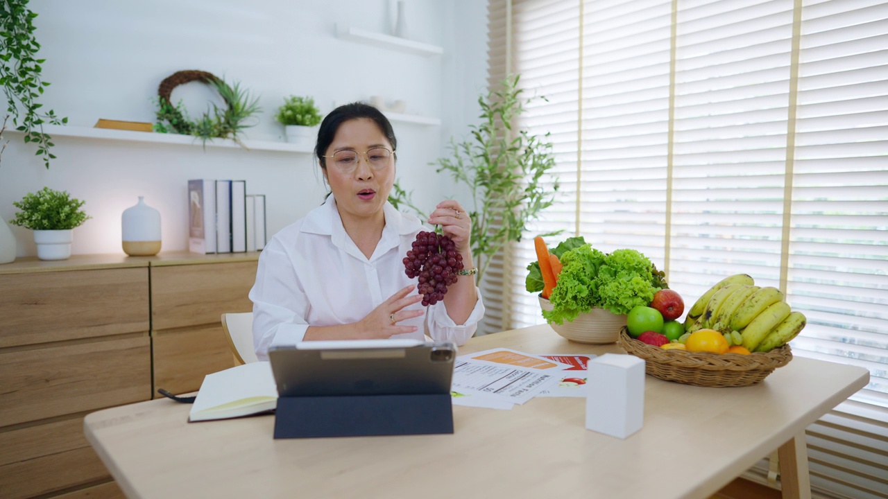 女性营养学家使用平板电脑视频电话与患者进行在线咨询。视频素材