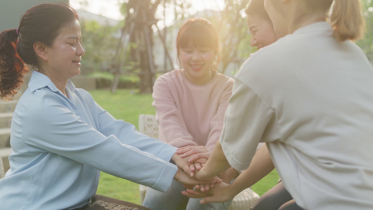 在公园里，不同的人分享他们悲伤的问题和故事，进行集体治疗。亚洲人围坐成一圈，手拉手，希望得到帮助。心理健康。视频素材