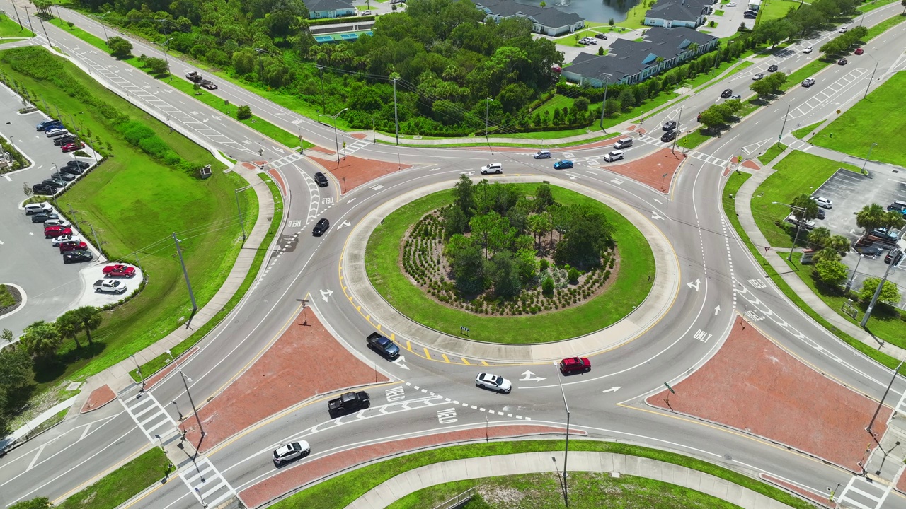 鸟瞰图的道路环岛交叉路口快速移动繁忙的交通。城市循环交通十字路口视频素材