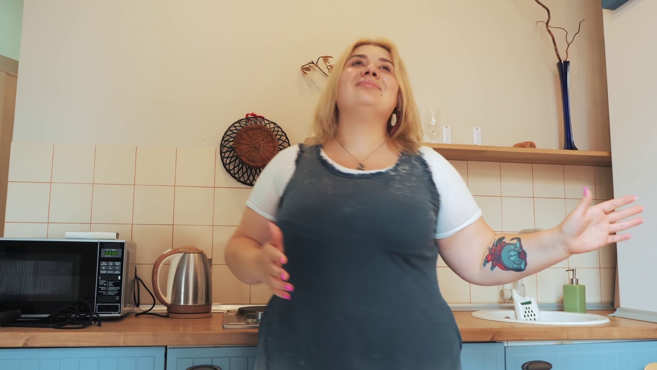 正码或超重的女性在家里的厨房跳舞视频素材