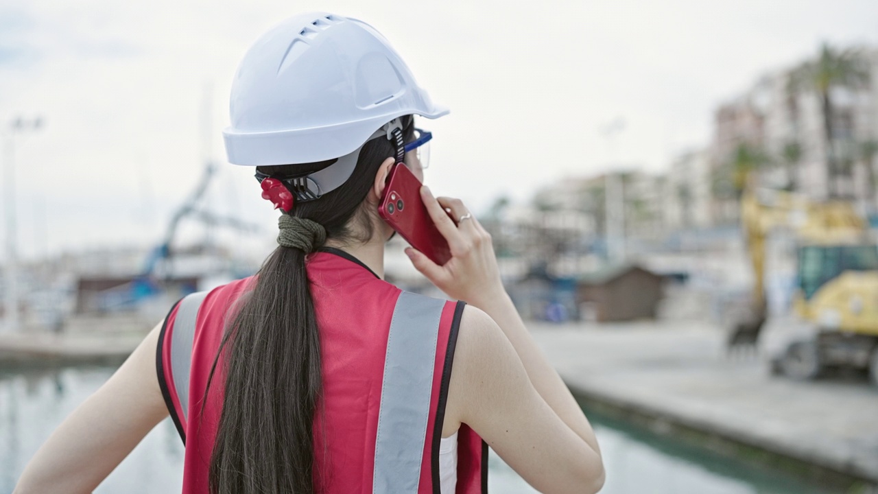 年轻美丽的西班牙裔女建筑师在海边用智能手机聊天视频素材